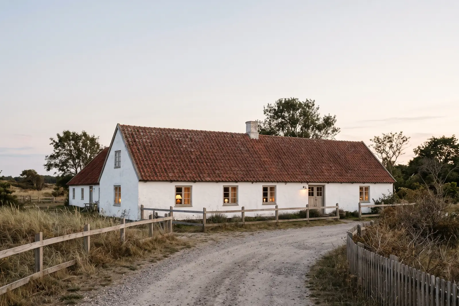 Lav hvid kro med røde tagsten i aftenlys. Lavet med AI